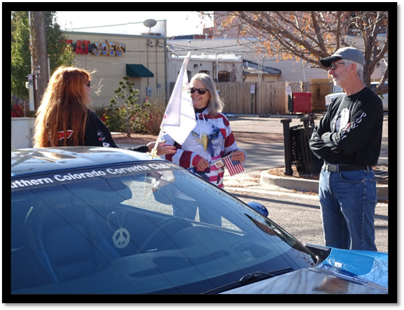 A group of people standing next to a car

Description automatically generated