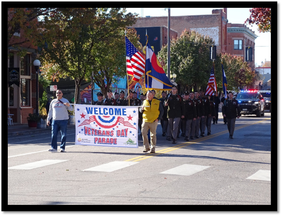 A group of people marching in a parade

Description automatically generated