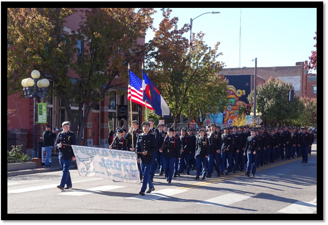 A group of people marching in a parade

Description automatically generated