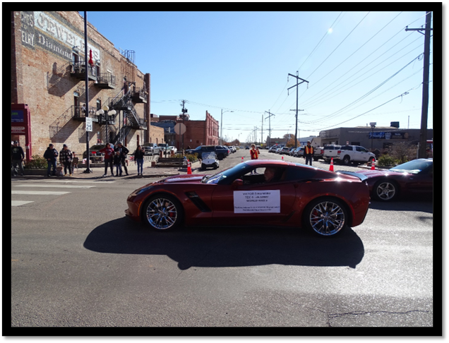 A red sports car parked on a street

Description automatically generated