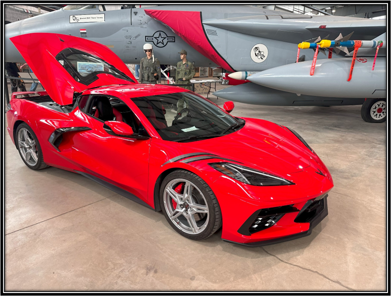 A red sports car parked next to a plane

Description automatically generated with low confidence